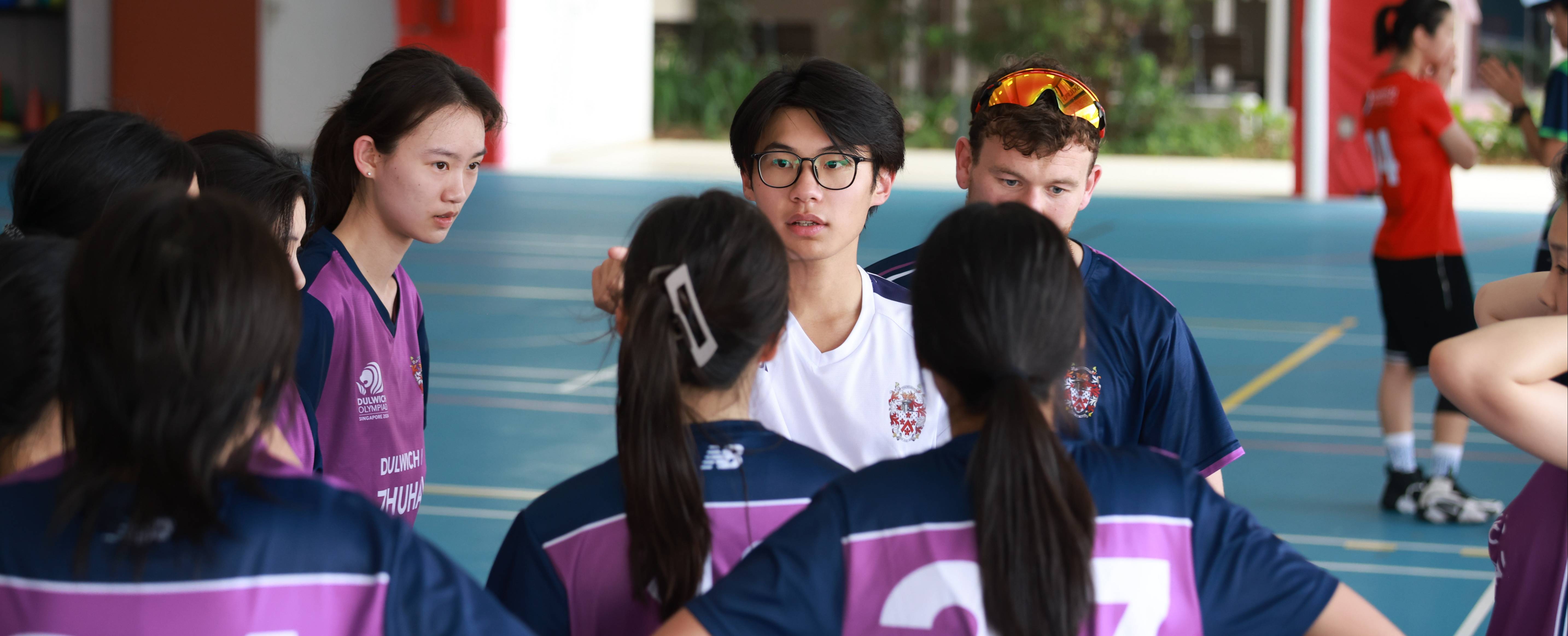 在德威奥林匹亚赛场上，  Brandon与校女子篮球队队员商量比赛策略