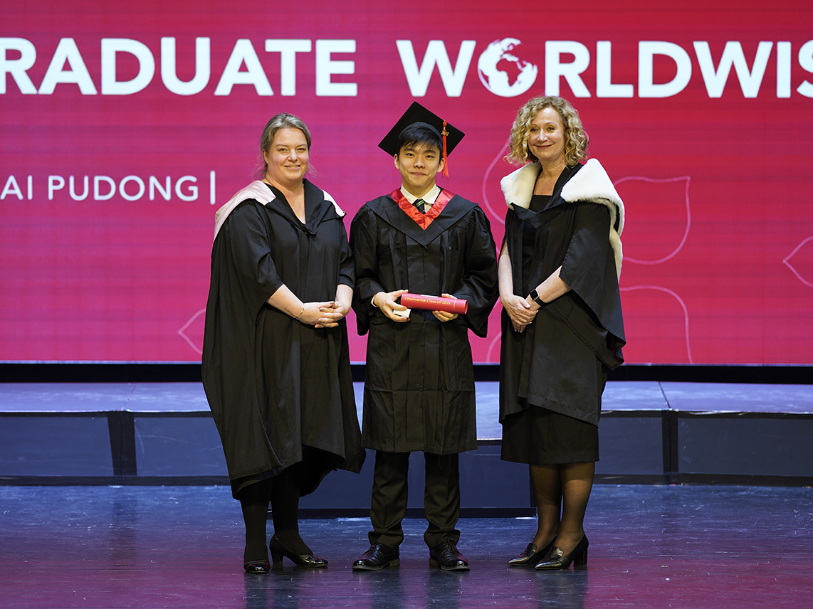 校长, Caroline Taylor 女士 (右一) 和中学校长, Alison Derbyshire 女士 (左一) 以及毕业生, Derek F (中间) 在毕业典礼上的合影