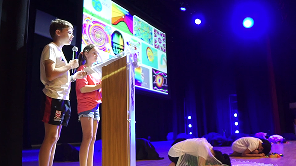 Two students speaking behind a podium in Dulwich College (Singapore) Primary School