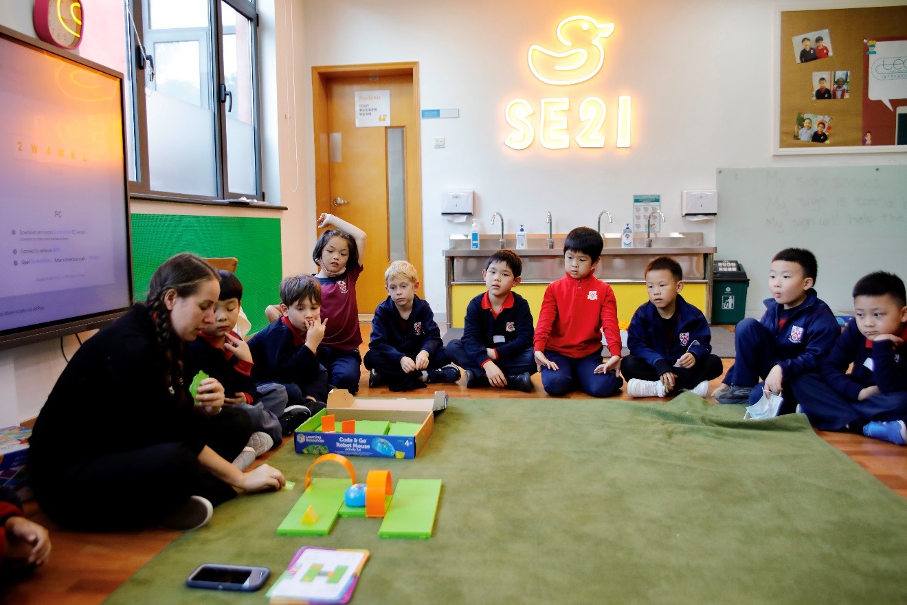 Students sit in a circle in the SE21 room at Shanghai Pudong DUCKS Kindergarten.